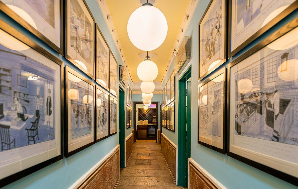 The English Mansion's collection wall, hung with signed photographs and works on paper
