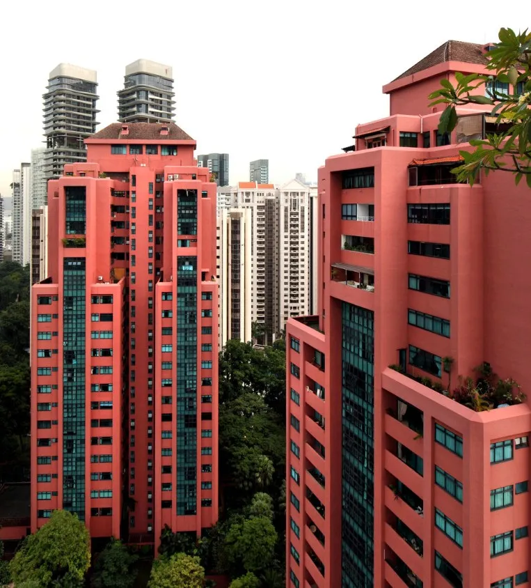 The coral-pink towers of Leonie Gardens condominium rising above the tree canopy on Leonie Hill, District 9, with the Orchard Road skyline behind