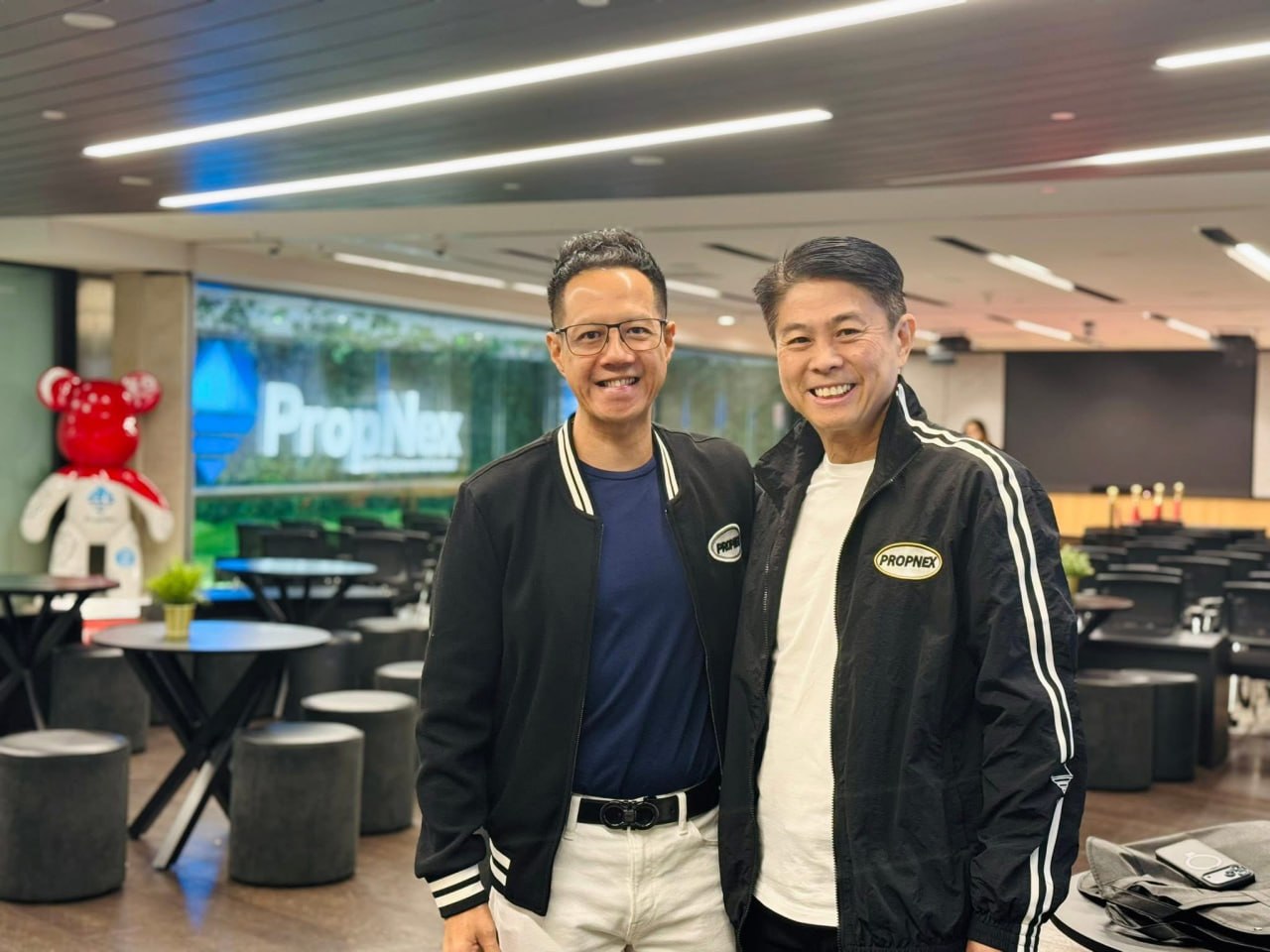 Adrian and a senior PropNex colleague smiling in the PropNex HQ lounge