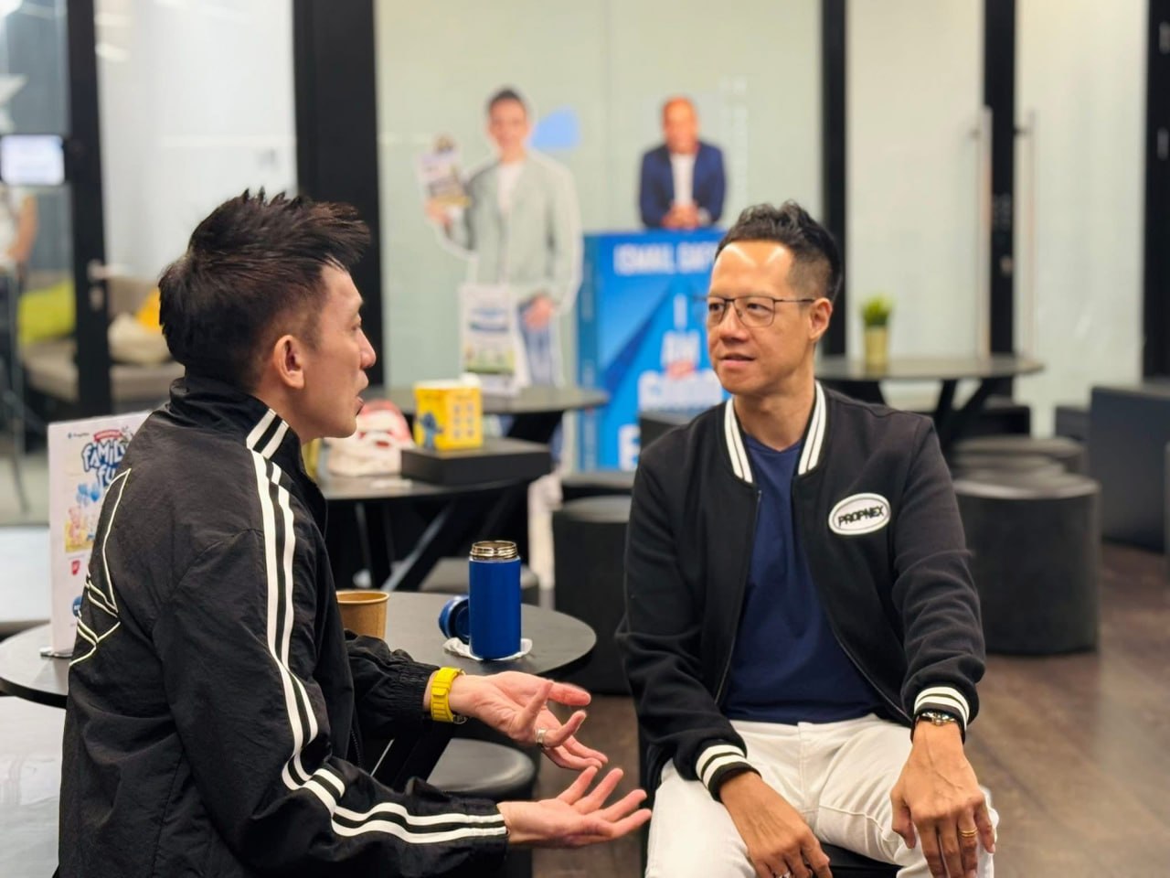 Adrian seated in conversation with PropNex CEO Kelvin Fong in the PropNex HQ lounge